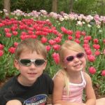 They pose by some beautiful flowers.